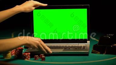 手打开笔记本电脑，扑克筹码和财富周围，诱惑击中大奖
